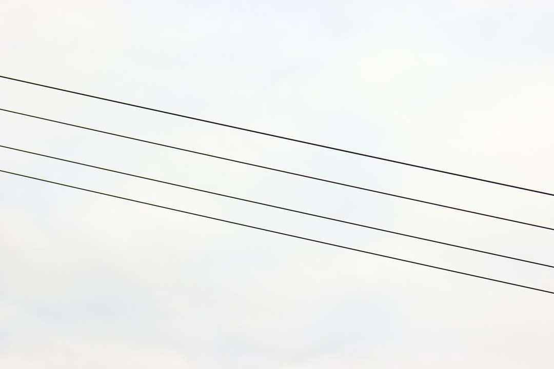 черни електрически проводници под бяло небе през деня онлайн пъзел