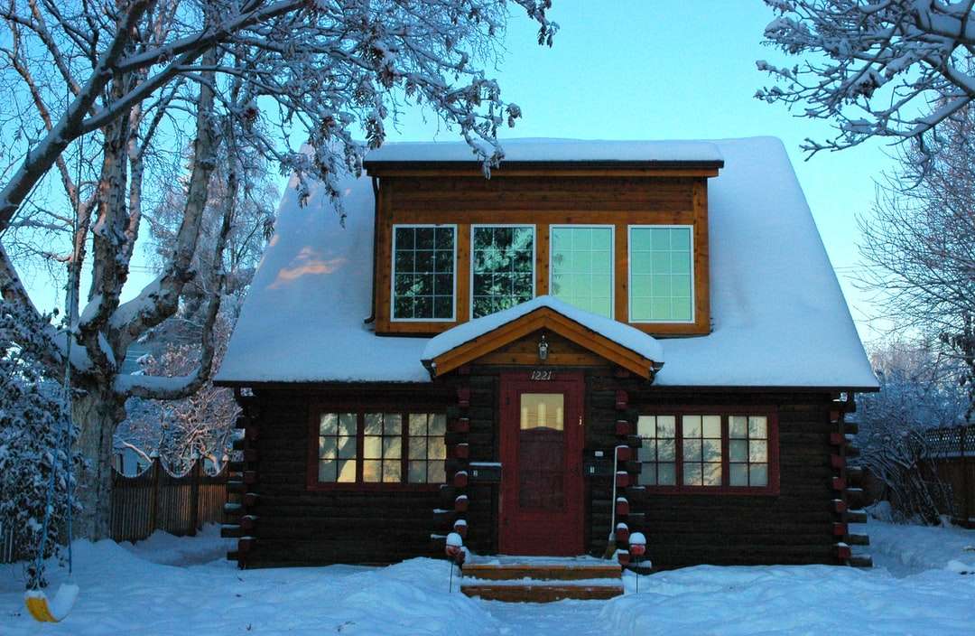 bruin houten huis bedekt met sneeuw overdag legpuzzel online