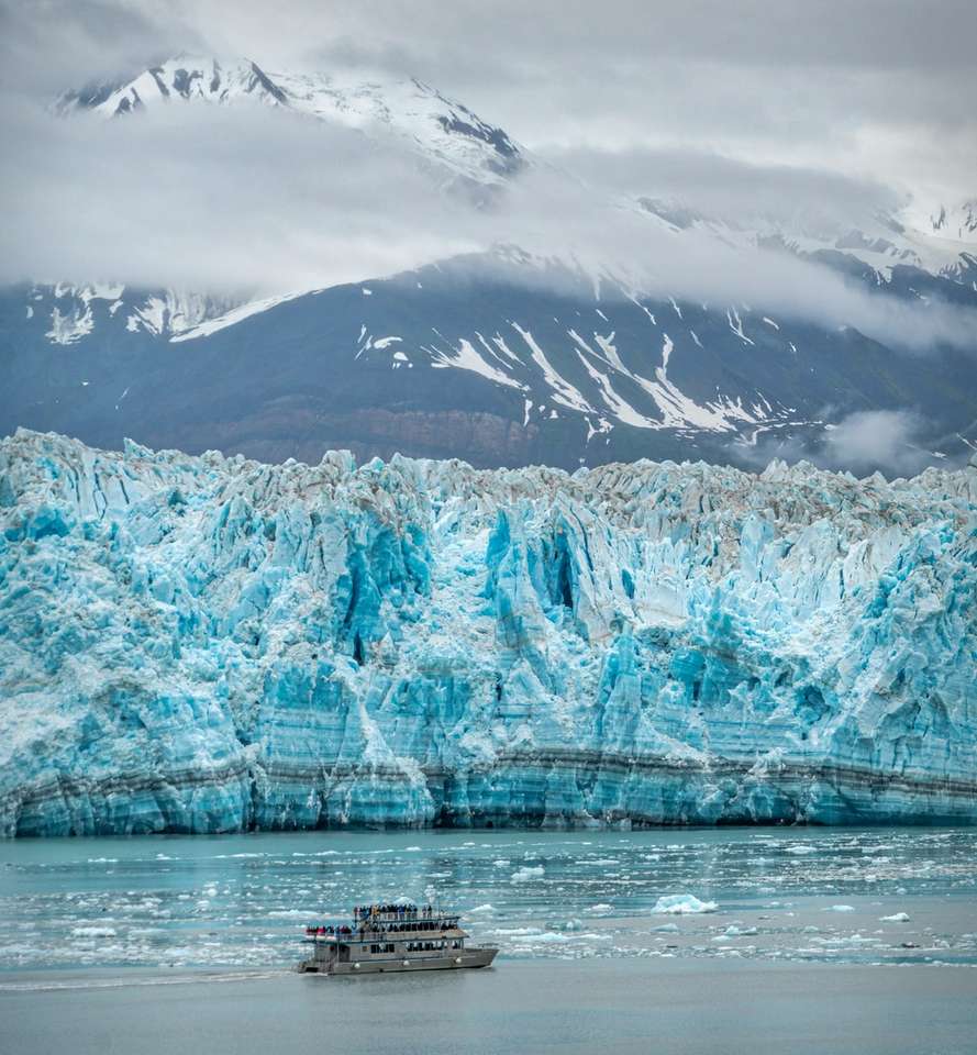 bílý člun na vodní hladině poblíž zasněžené hory online puzzle
