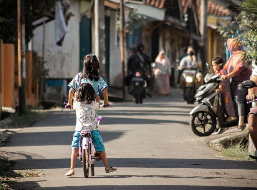 garota de vestido azul e branco andando de bicicleta na estrada quebra-cabeças online
