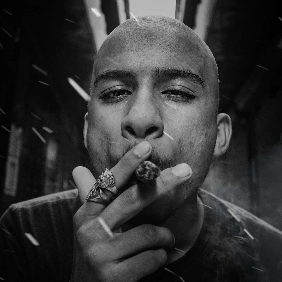 Homme fumant une cigarette en photographie en niveaux de gris puzzle en ligne