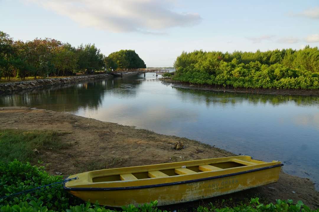 коричневий дерев'яний човен на озері в денний час онлайн пазл