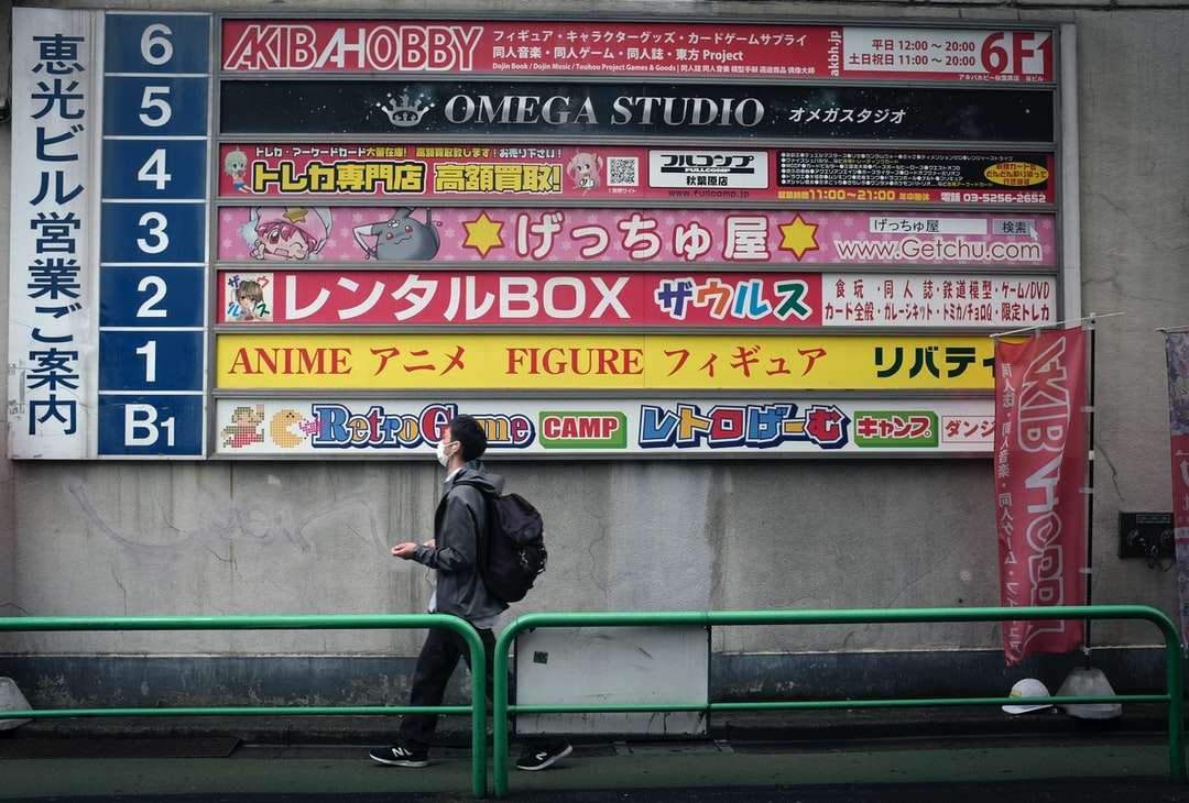 homem de jaqueta preta sentado em um banco de metal verde quebra-cabeças online