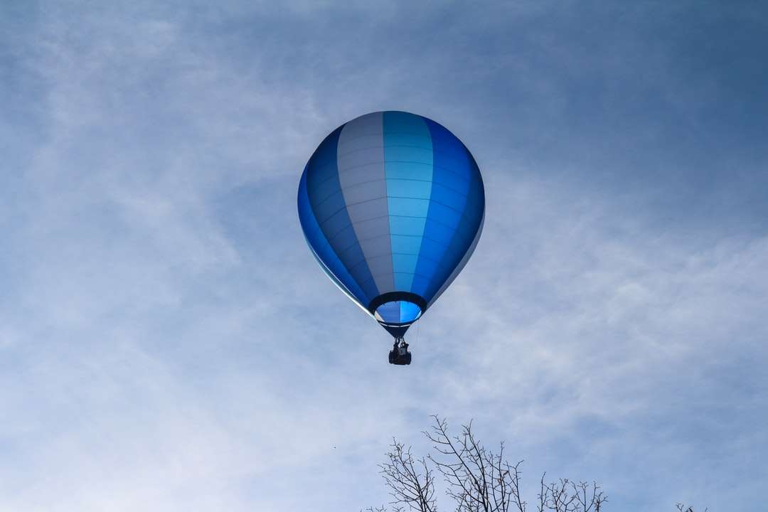 синьо-бял балон с горещ въздух под синьо небе през деня онлайн пъзел