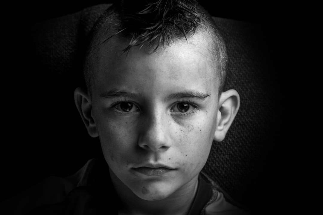 Foto en escala de grises de un niño con camisa con cuello rompecabezas en línea