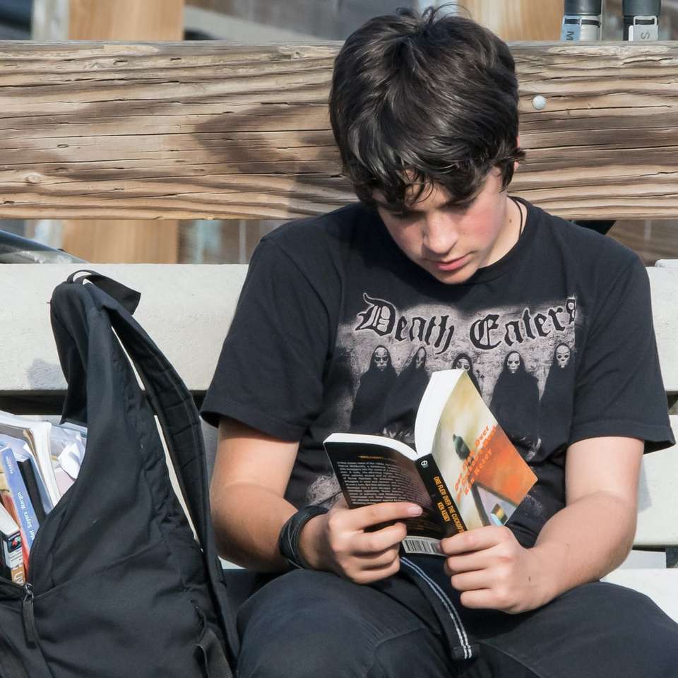 man in zwarte ronde hals t-shirt zittend op een zwarte stoel legpuzzel online