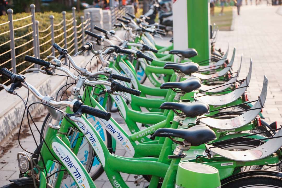 lote de bicicletas verdes em cerca de aço cinza durante o dia quebra-cabeças online