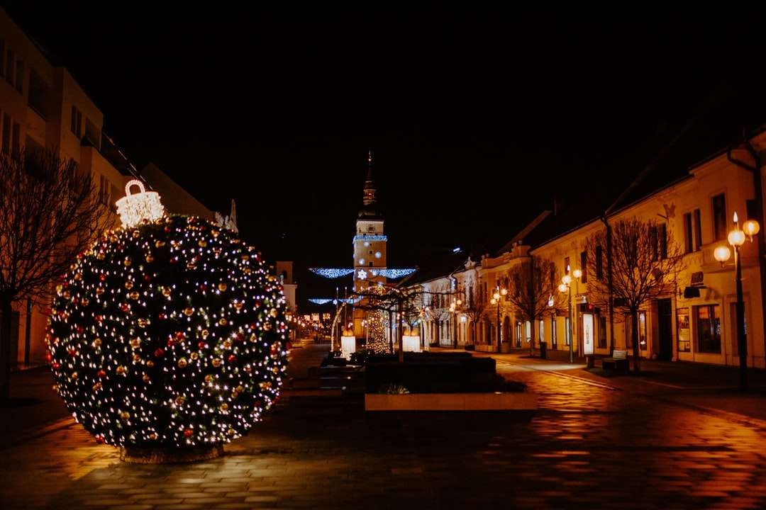 árvore de natal iluminada perto do prédio durante a noite puzzle online