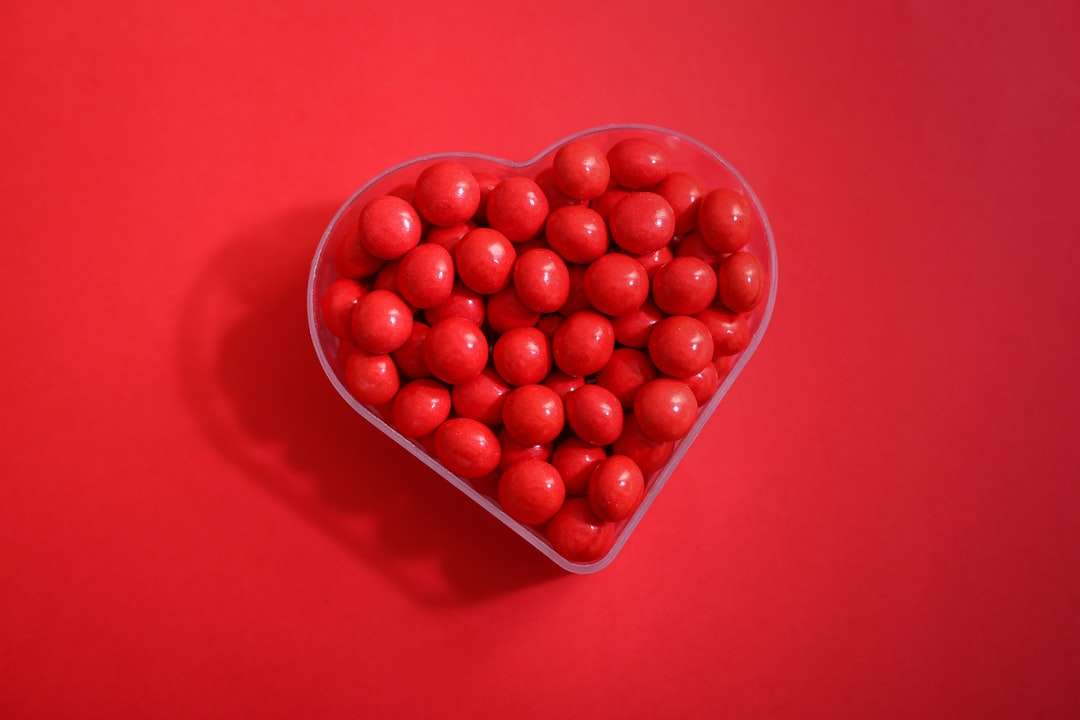 червени кръгли плодове върху червен пластмасов съд онлайн пъзел