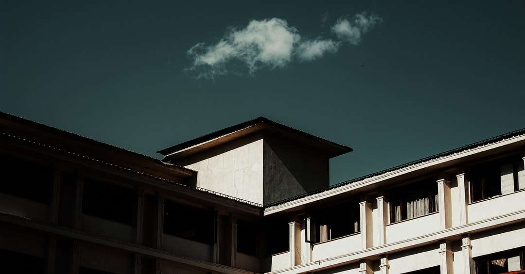 edificio in cemento marrone e bianco sotto il cielo blu puzzle online