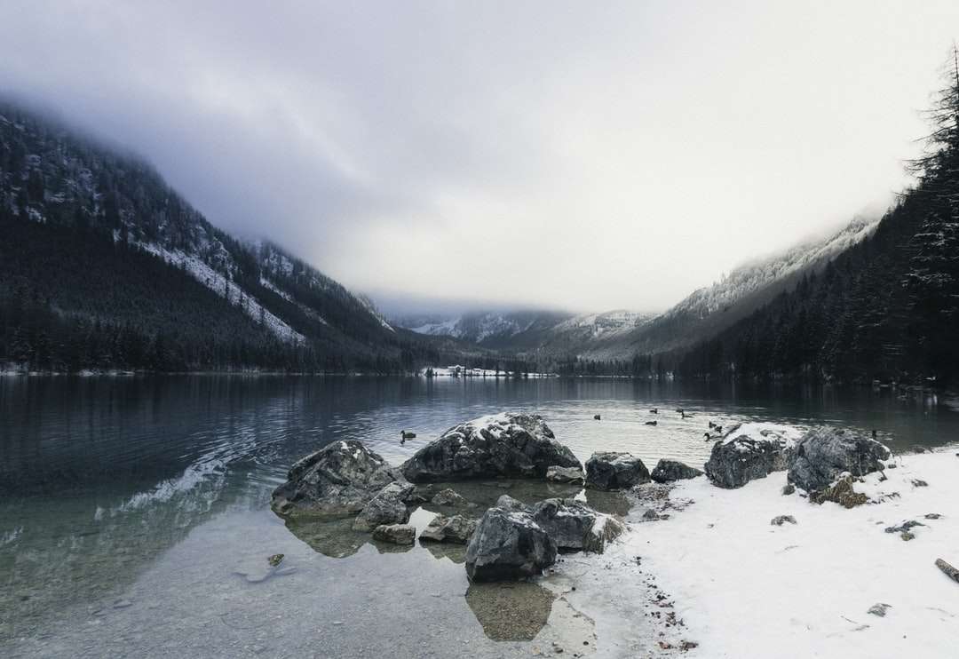šedé kameny na jezeře poblíž hory během dne skládačky online