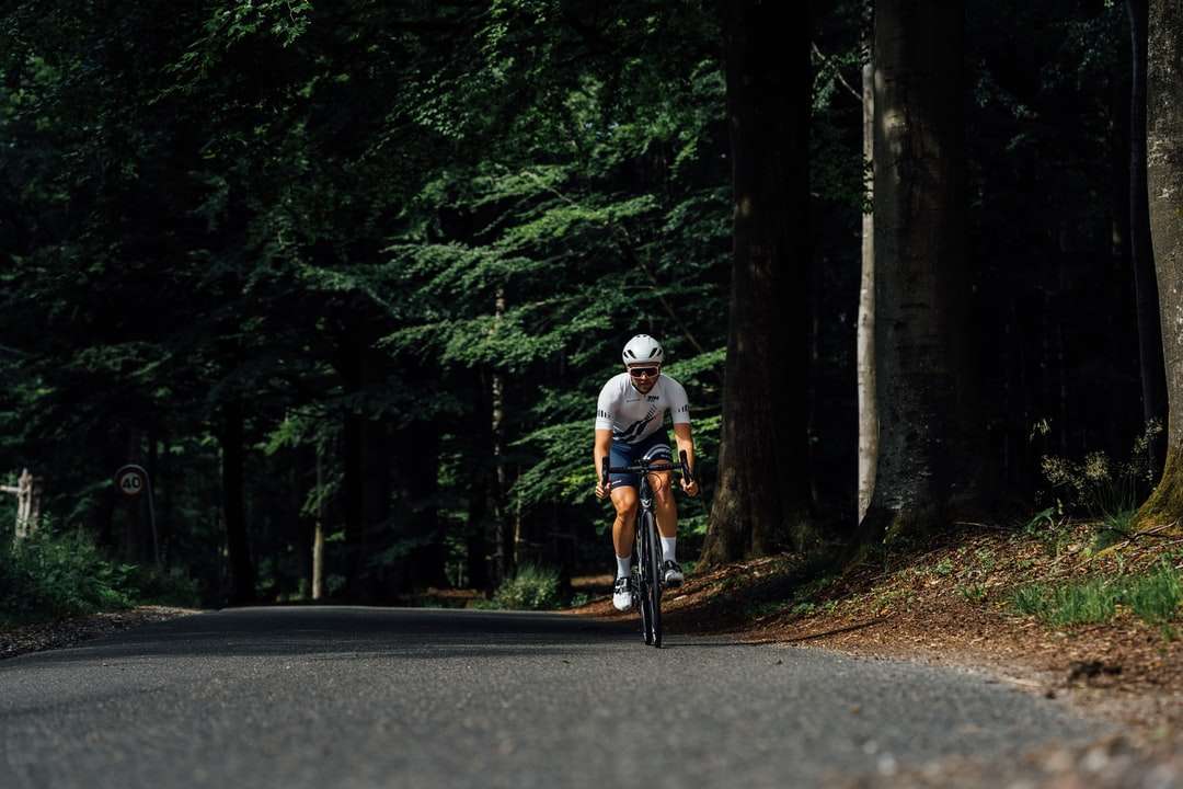 Hombre con casco blanco montando bicicleta en la carretera durante el día rompecabezas en línea