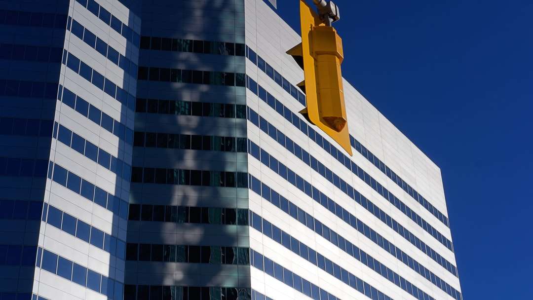 Bouche d'incendie jaune près d'un bâtiment en béton blanc et bleu puzzle en ligne