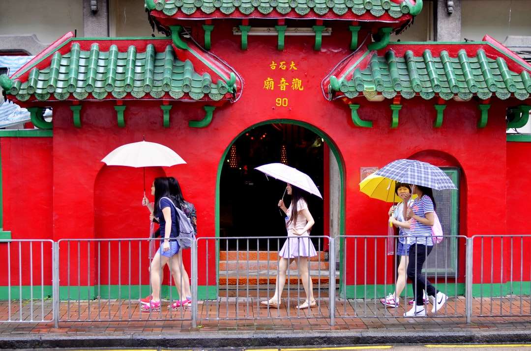 Mann und Frau halten Regenschirm, der auf Bürgersteig geht Puzzlespiel online