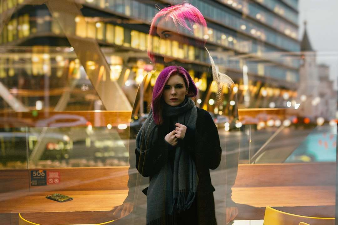 Frau im schwarzen Mantel, der nahe Glaswand steht Puzzlespiel online