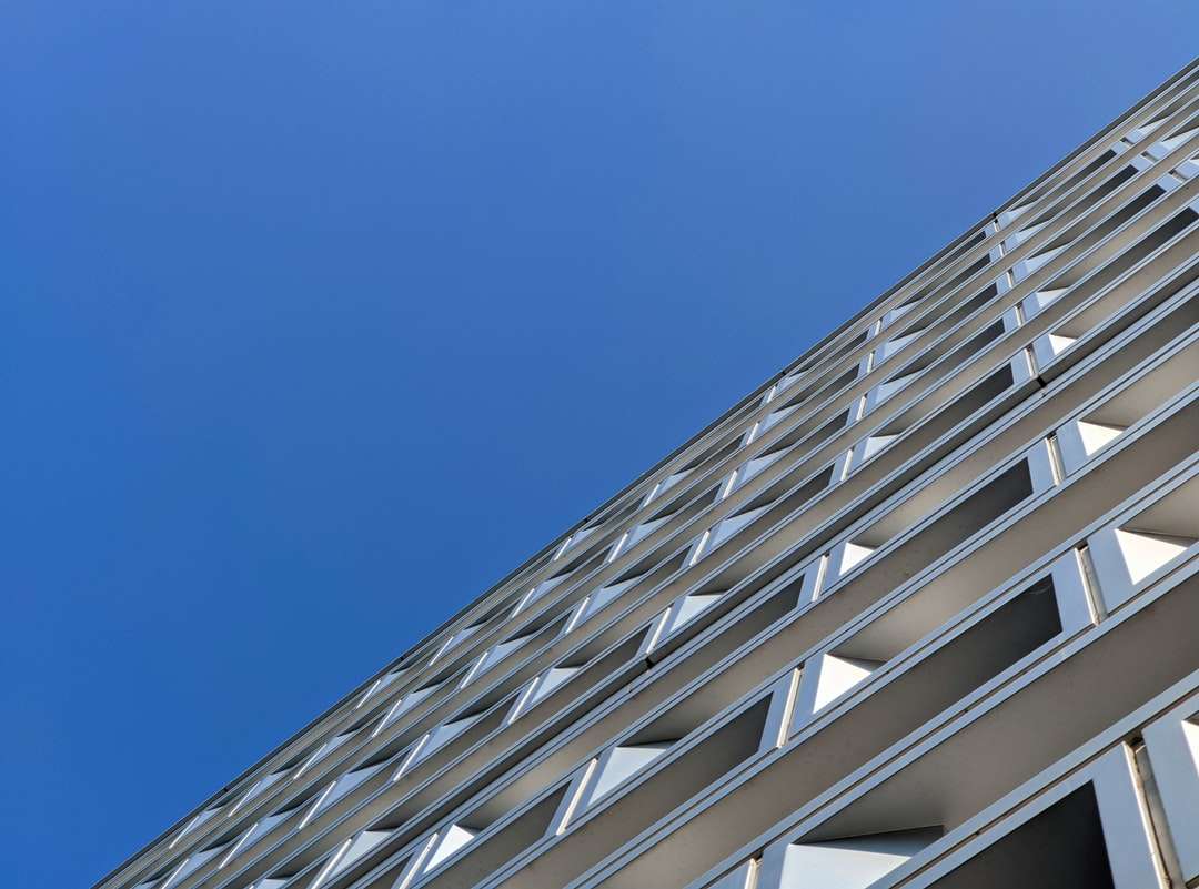біла бетонна будівля під блакитним небом вдень пазл онлайн