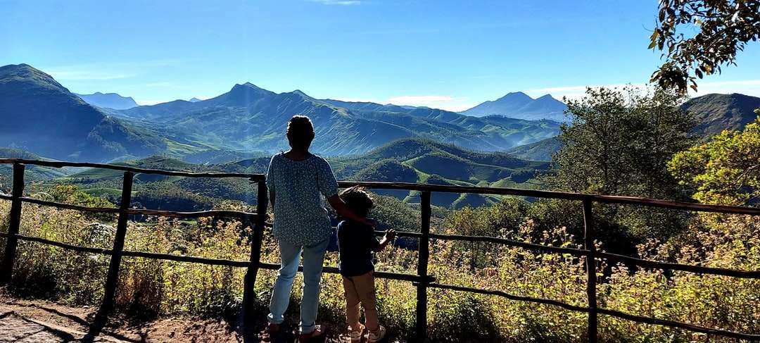 Mann und Frau stehen auf Balkon und betrachten Berge Puzzlespiel online