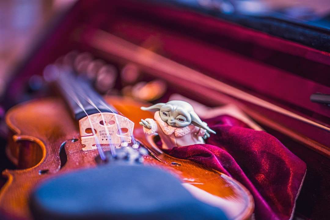 коричнева скрипка на червоному текстилі онлайн пазл