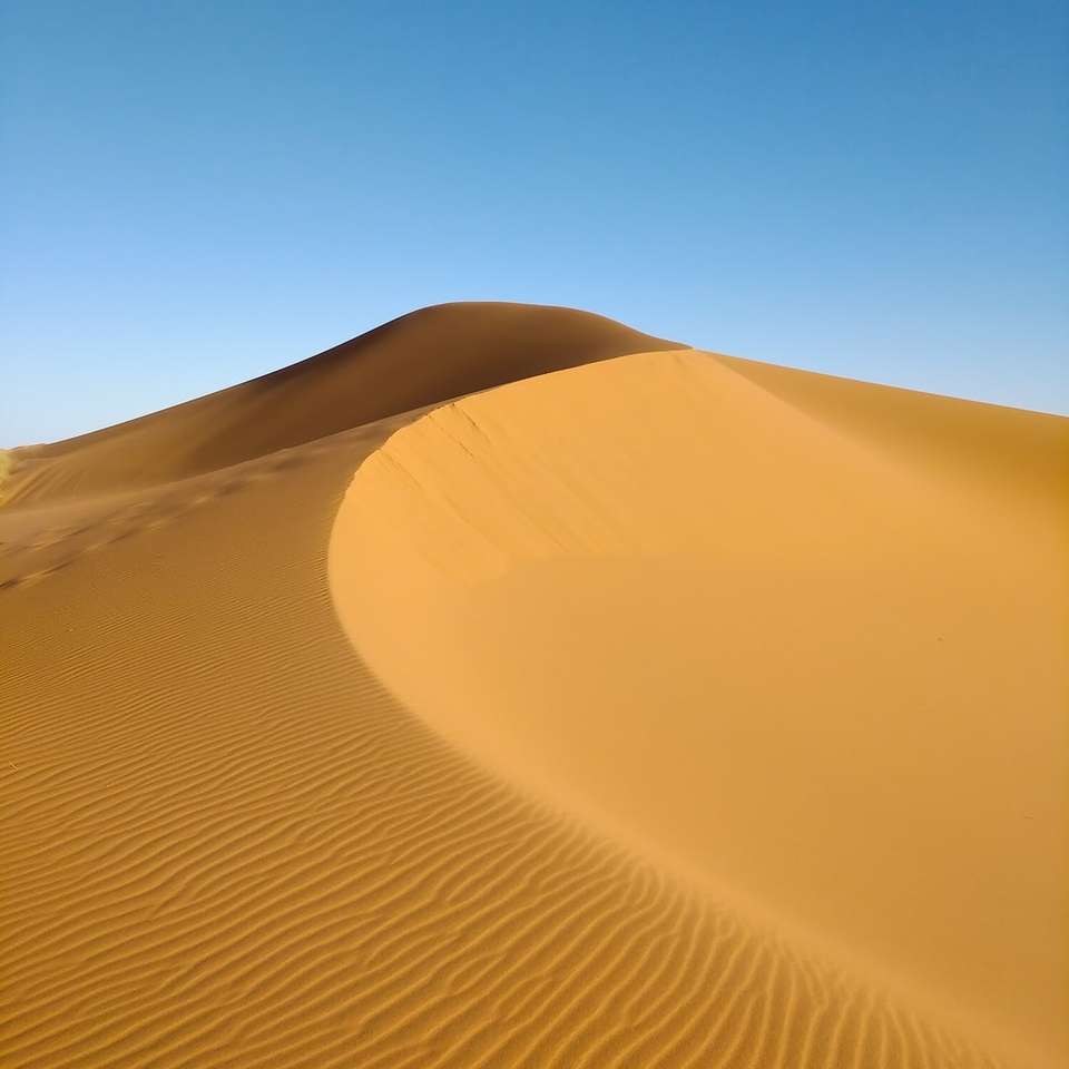 кафяв пясък под синьо небе през деня онлайн пъзел