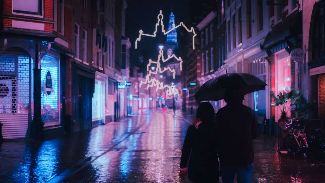 persoon in zwarte jas met paraplu lopen op straat legpuzzel online
