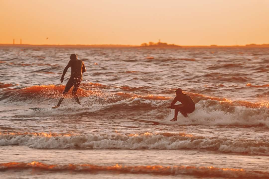 2 χέρια εκμετάλλευσης ανδρών και γυναικών στην παραλία κατά τη διάρκεια του ηλιοβασιλέματος παζλ online