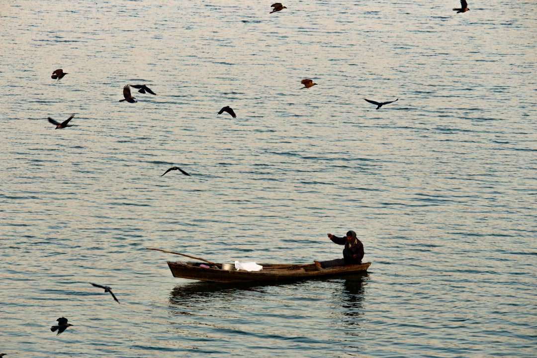 El hombre y la mujer cabalgando sobre un barco marrón en el cuerpo de agua rompecabezas en línea
