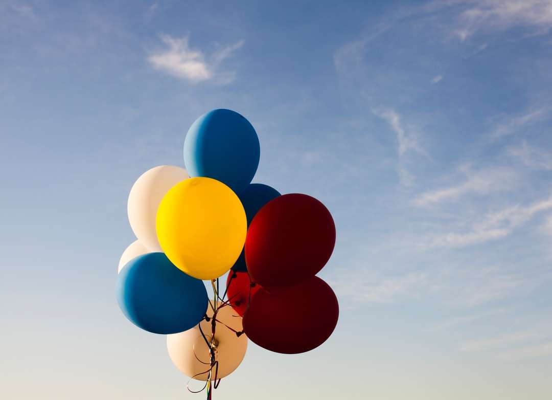 globos blancos, amarillos, rojos y azules bajo un cielo azul rompecabezas en línea