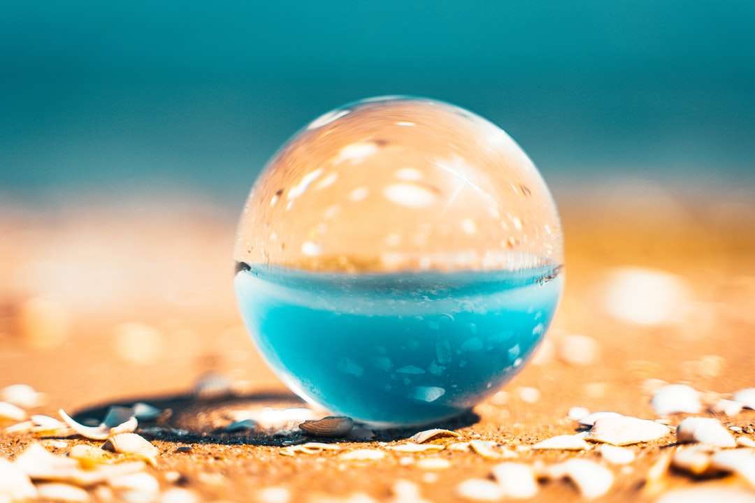 прозрачна стъклена топка върху кафяв пясък онлайн пъзел