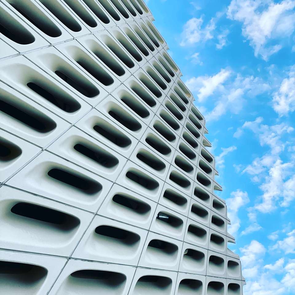біла бетонна будівля під блакитним небом вдень онлайн пазл