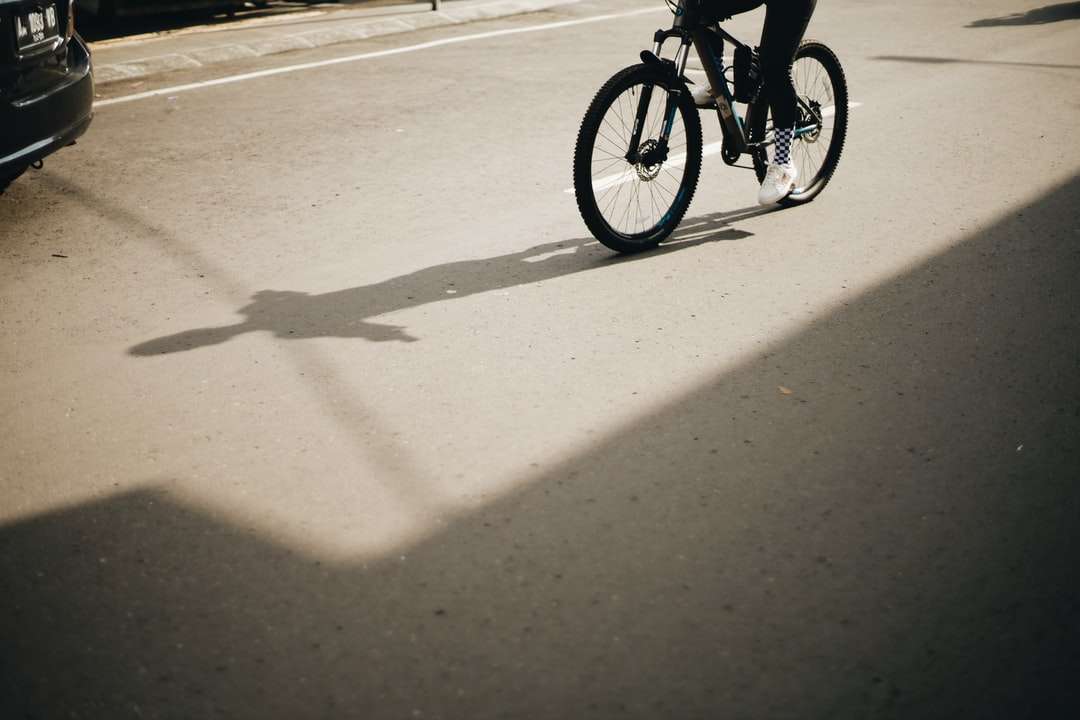 човек, който кара велосипед по пътя през деня онлайн пъзел