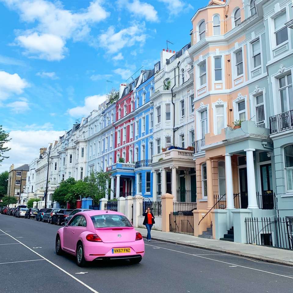 rosa bil på vägen nära vit betongbyggnad under dagtid Pussel online