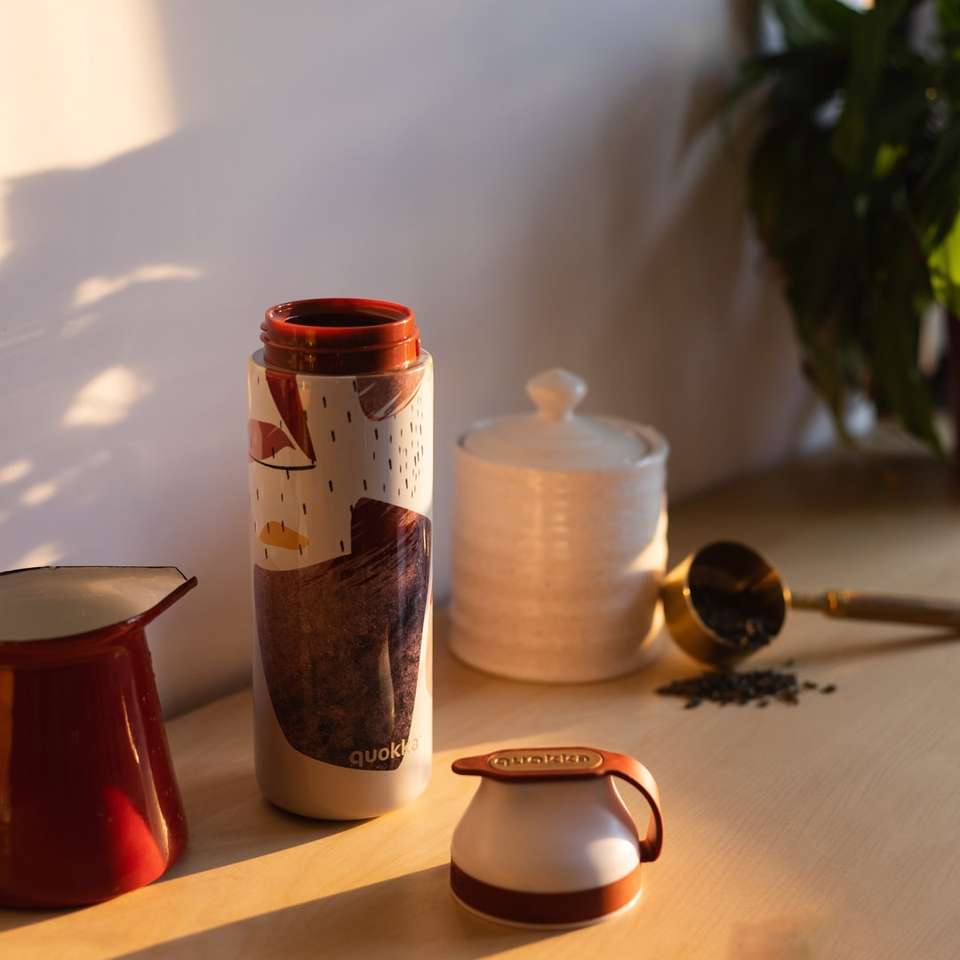 tasse en céramique rouge à côté de tasse en céramique blanche et brune puzzle en ligne