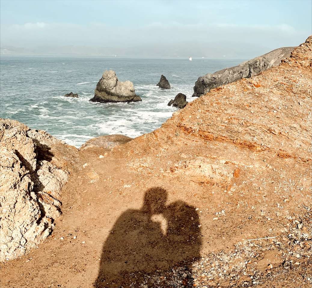 braune Felsformation in der Nähe von Gewässern während des Tages Online-Puzzle