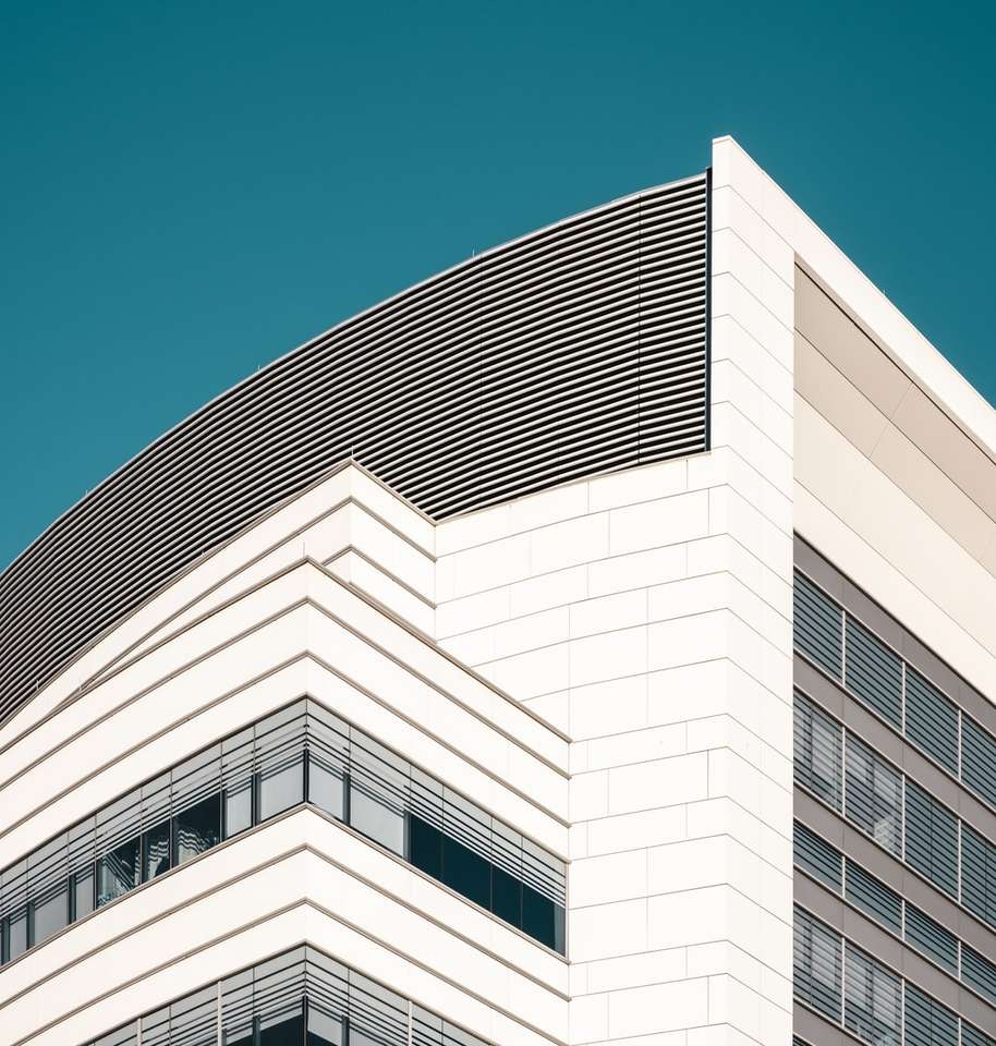 edifício de concreto branco sob céu azul durante o dia quebra-cabeças online