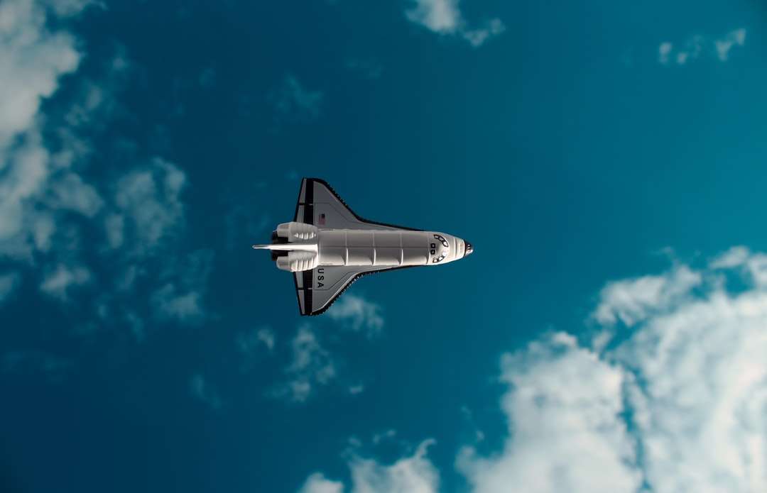 Avión a reacción blanco y negro en el aire bajo un cielo azul rompecabezas en línea