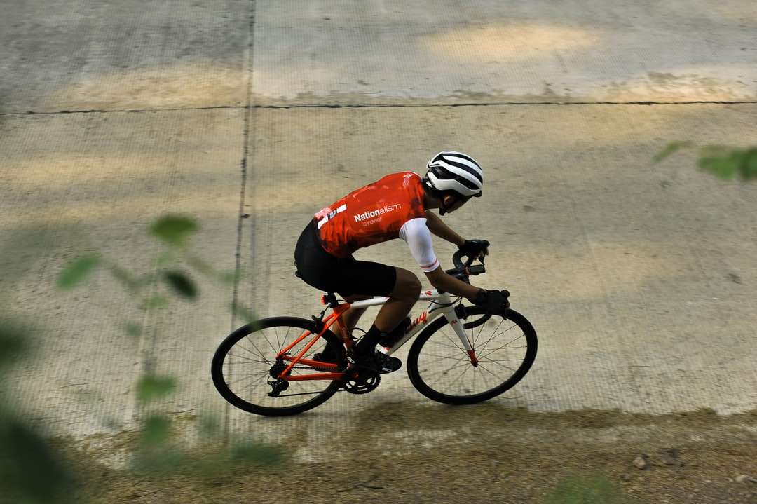 Hombre en casco de bicicleta rojo y blanco montando rompecabezas en línea