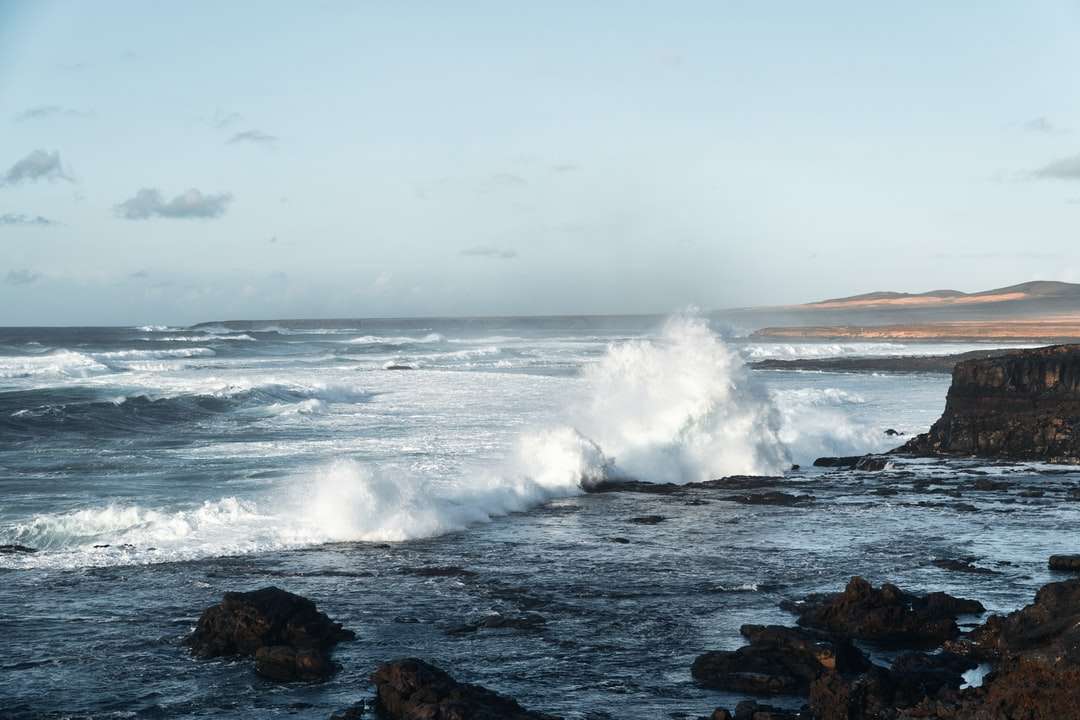 ωκεάνια κύματα συντρίβονται πάνω σε βράχους κατά τη διάρκεια της ημέρας παζλ online