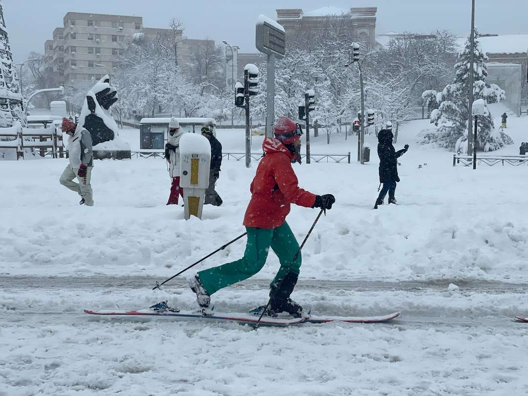 gente en chaqueta roja y pantalones jugando al esquí rompecabezas en línea