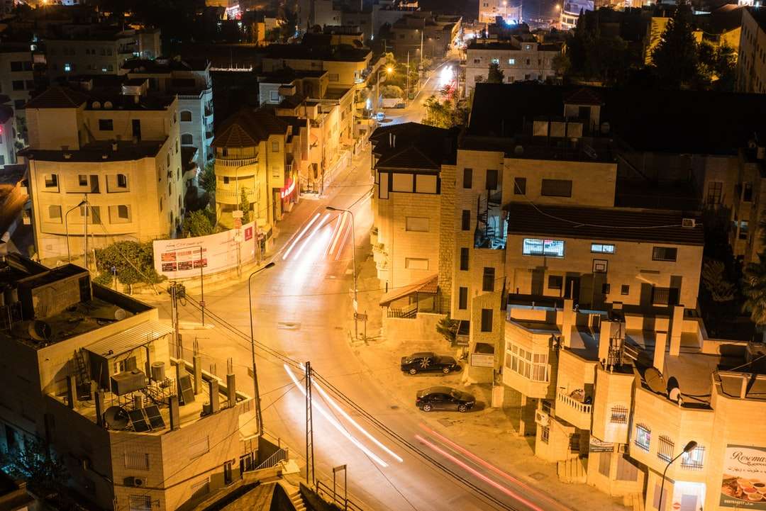 Autos auf der Straße in der Nähe von Gebäuden in der Nacht Puzzlespiel online