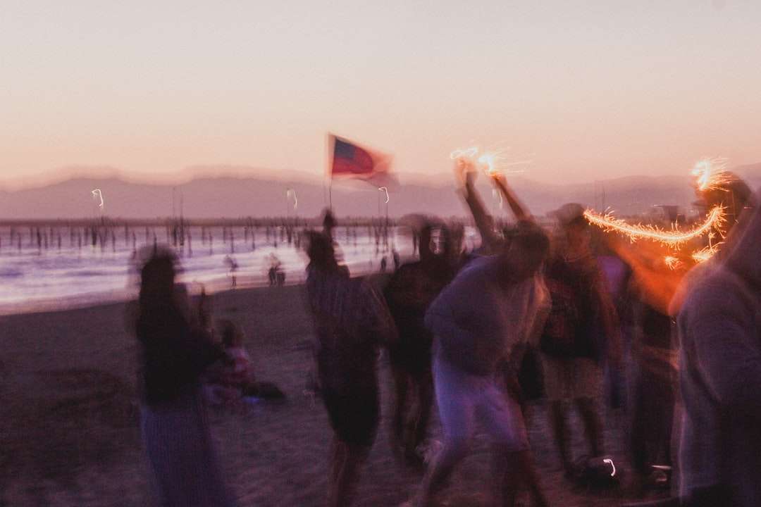 хора, стоящи на брега на плажа по време на залез онлайн пъзел
