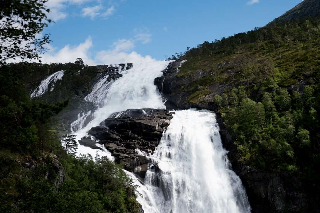 водопади на скалиста планина под синьо небе през деня онлайн пъзел