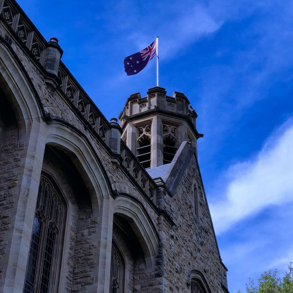 фотография с нисък ъгъл на бетонна сграда с флаг онлайн пъзел