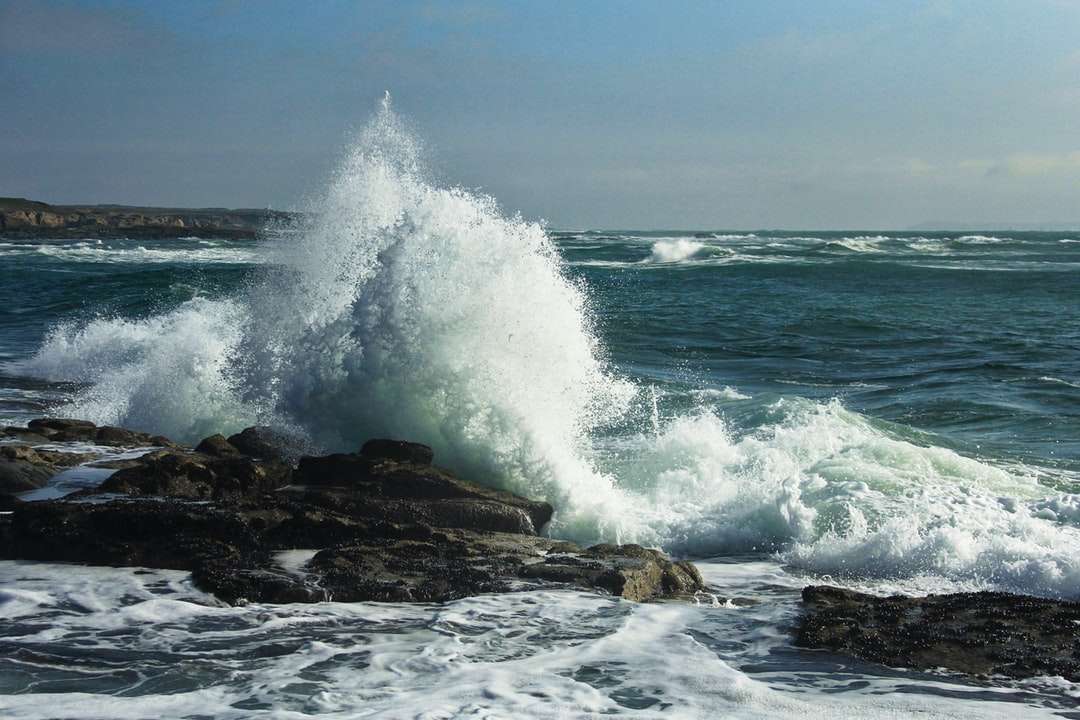 ocean waves crashing on brown rock formation during daytime online puzzle
