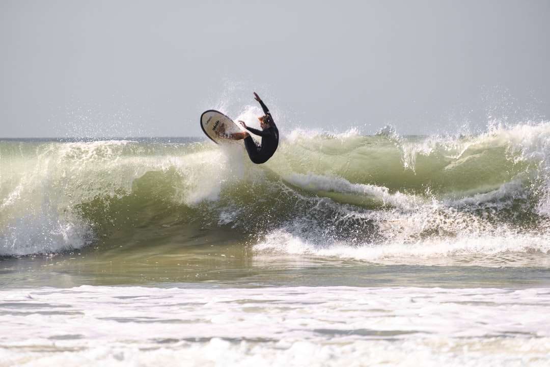 muž surfování na mořských vlnách během dne skládačky online