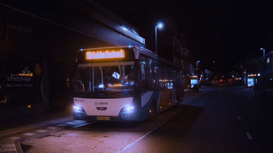 weißer und roter Bus auf der Straße während der Nachtzeit Online-Puzzle