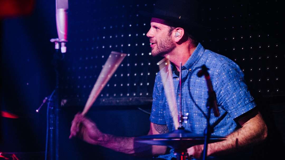 青いボタンアップシャツの男がドラムを演奏 ジグソーパズルオンライン
