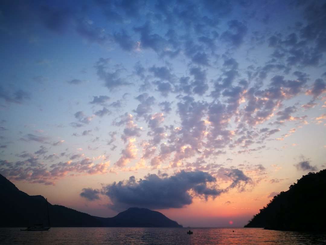 σιλουέτα του βουνού κάτω από συννεφιασμένο ουρανό κατά το ηλιοβασίλεμα παζλ online