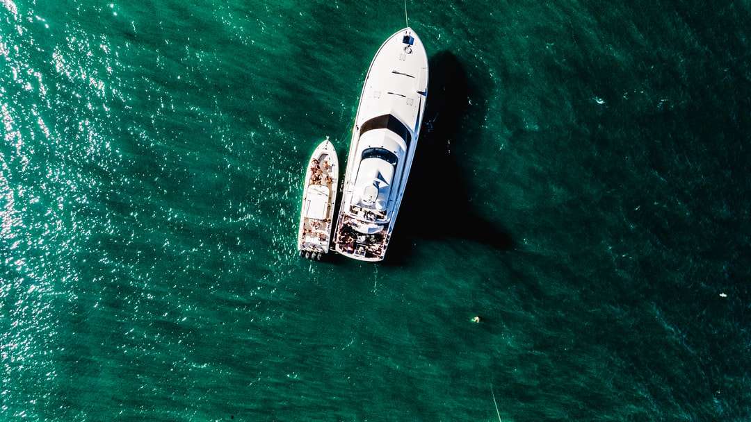 Barco blanco y marrón sobre el mar verde durante el día rompecabezas en línea