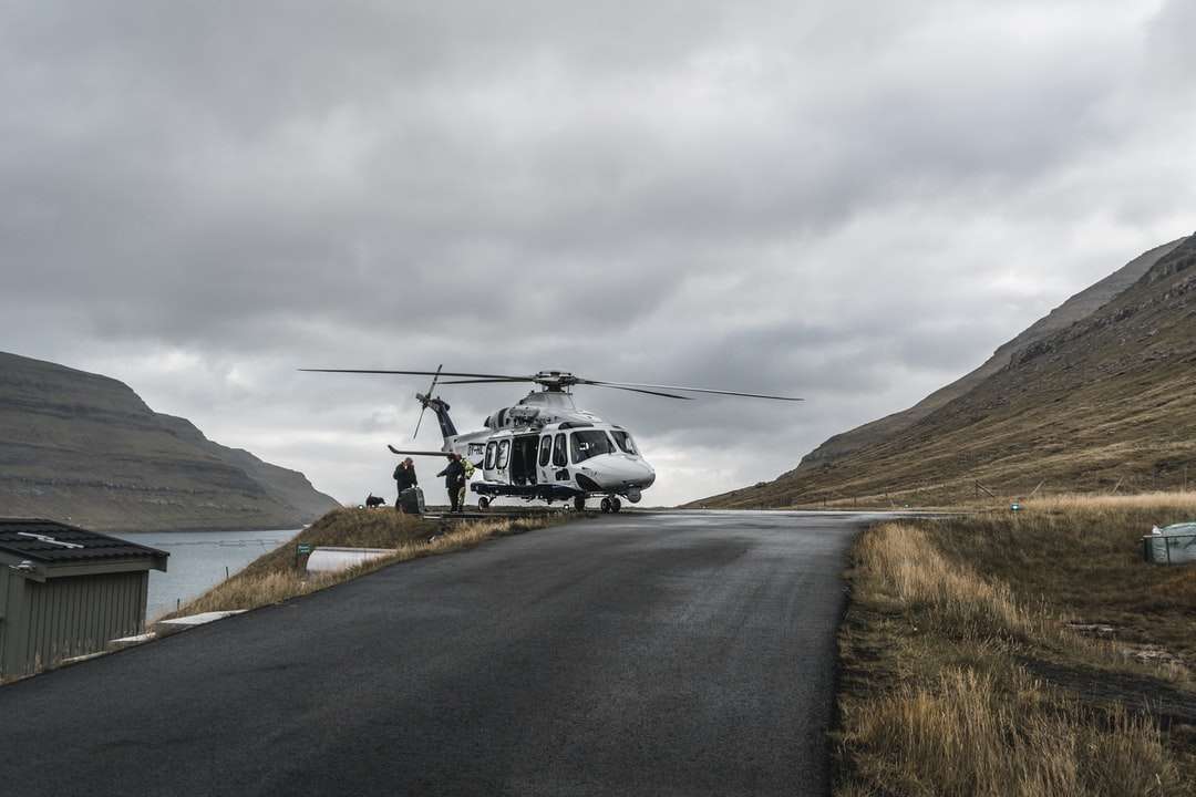helicóptero blanco y negro sobrevolando la montaña. rompecabezas en línea