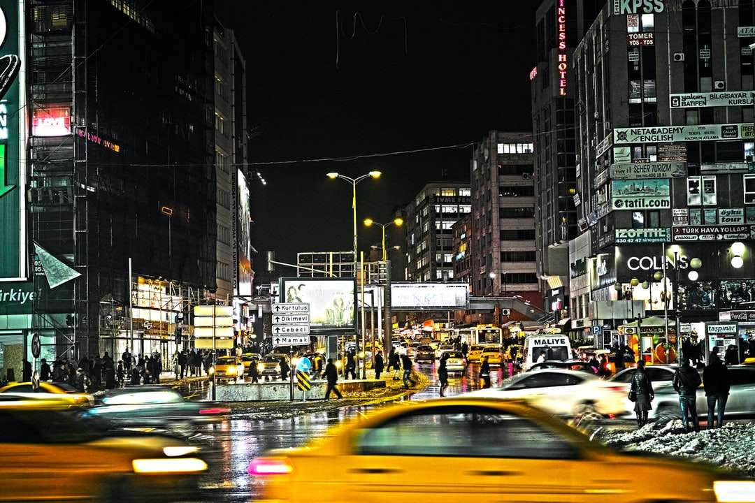 автомобили на дороге между зданиями в ночное время пазл онлайн